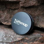 150ml Aluminium tin of Tuffenup's HARD GRIT exfoliating skin care on a stone surface